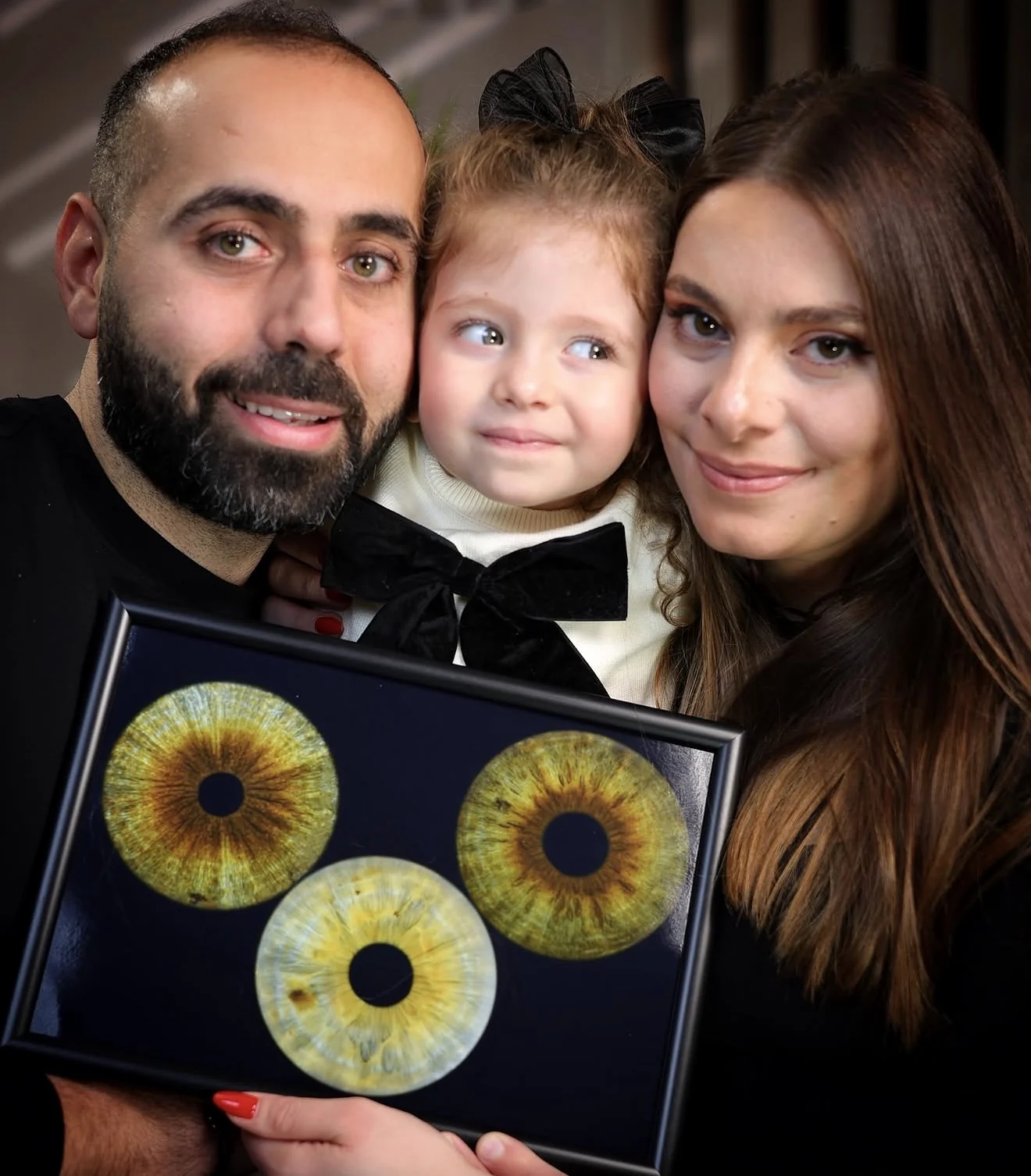 Family holding their framed iris artwork